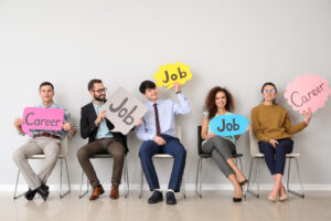 Young people holding speech bubbles with words JOB and CAREER indoors