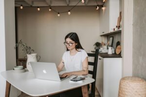 Focused young businesswoman using laptop at home